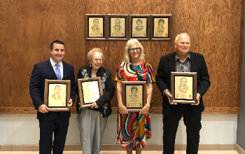 Doris Barber (faculty), Carol Buchanan (faculty), Dominic Caruso (Class of 1994), and Ed Herrick (faculty and Class of 1965) pose with Gallery of Achievement plaques. 